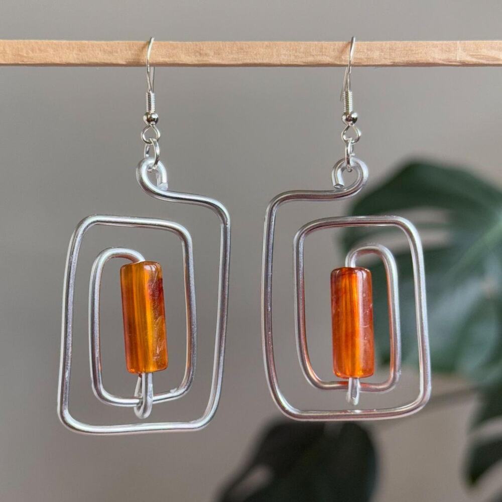 handmade silver wire spiral earrings with burnt orange colored tube beads